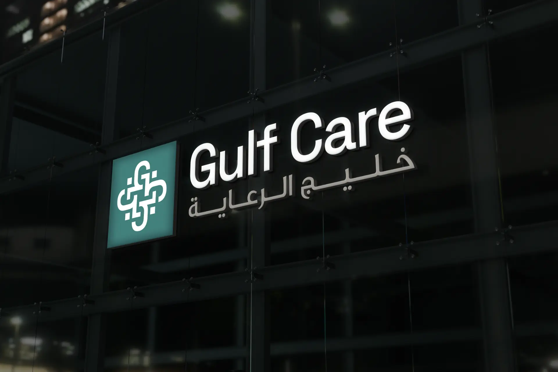 Gulf Care logo and Arabic name illuminated on the dark glass facade of a modern building at night
